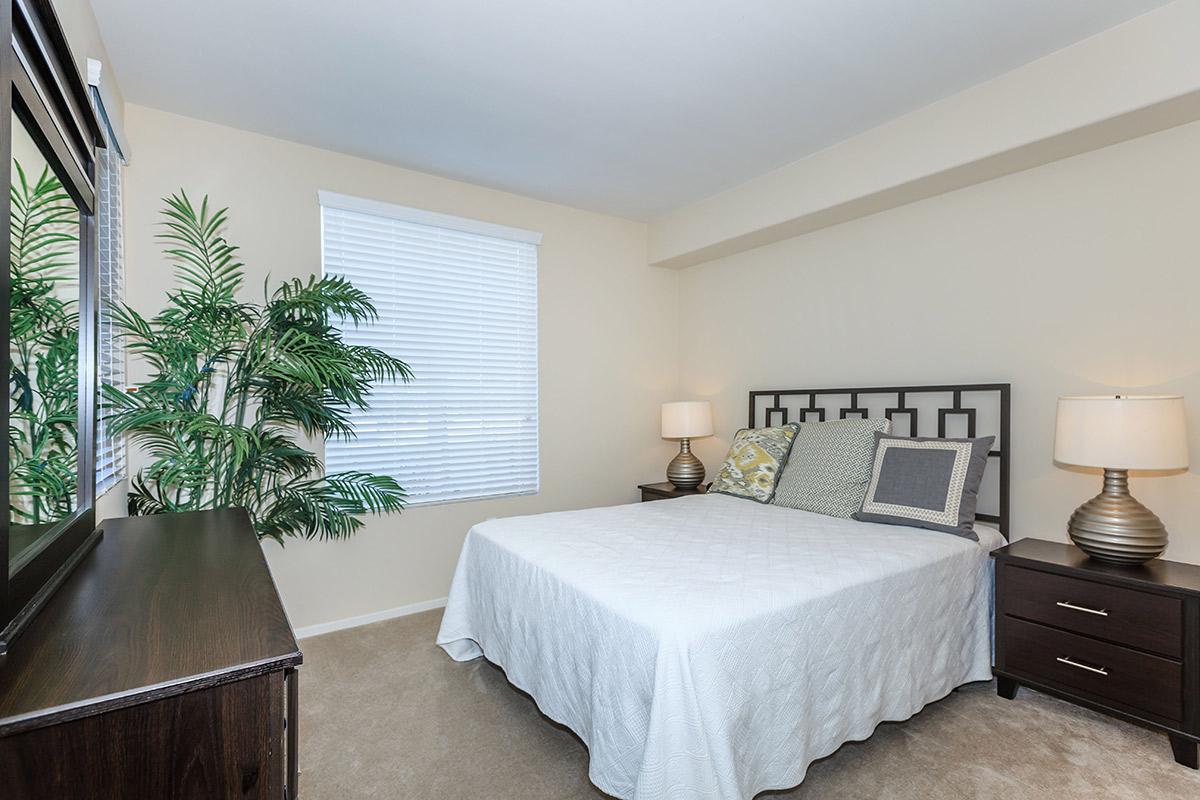 a bedroom with a bed and desk in a room