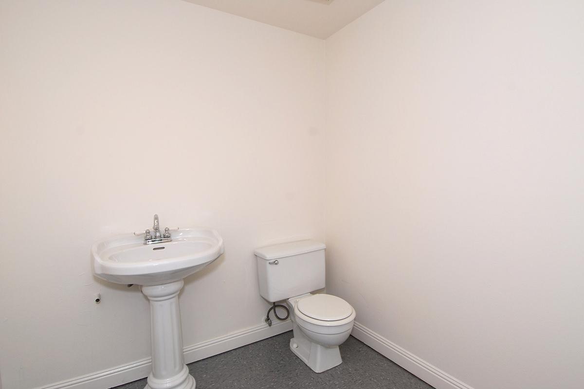 a white sink sitting under a mirror