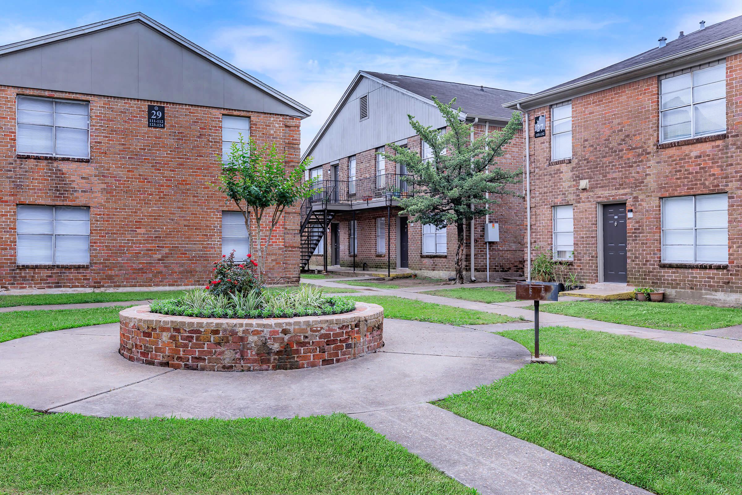 a large lawn in front of a brick building