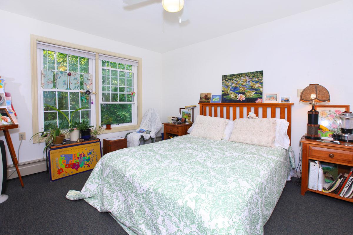 a bedroom with a bed and desk in a small room