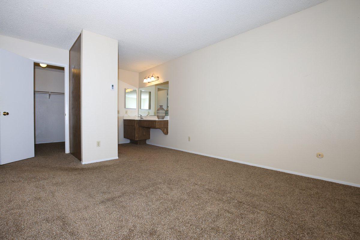 a bedroom with a bed and desk in a small room