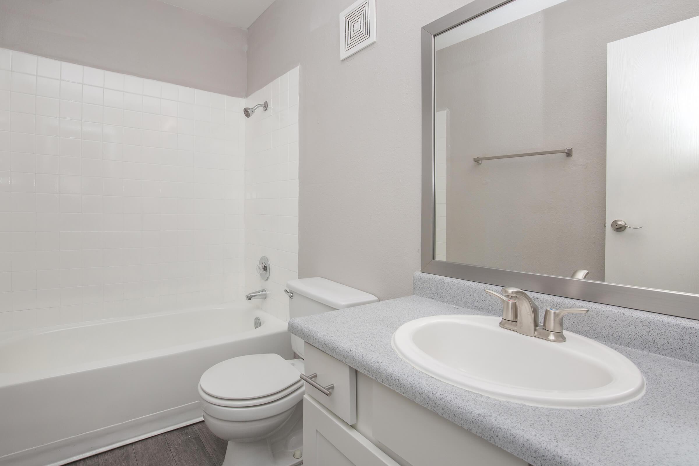 a white sink sitting under a mirror