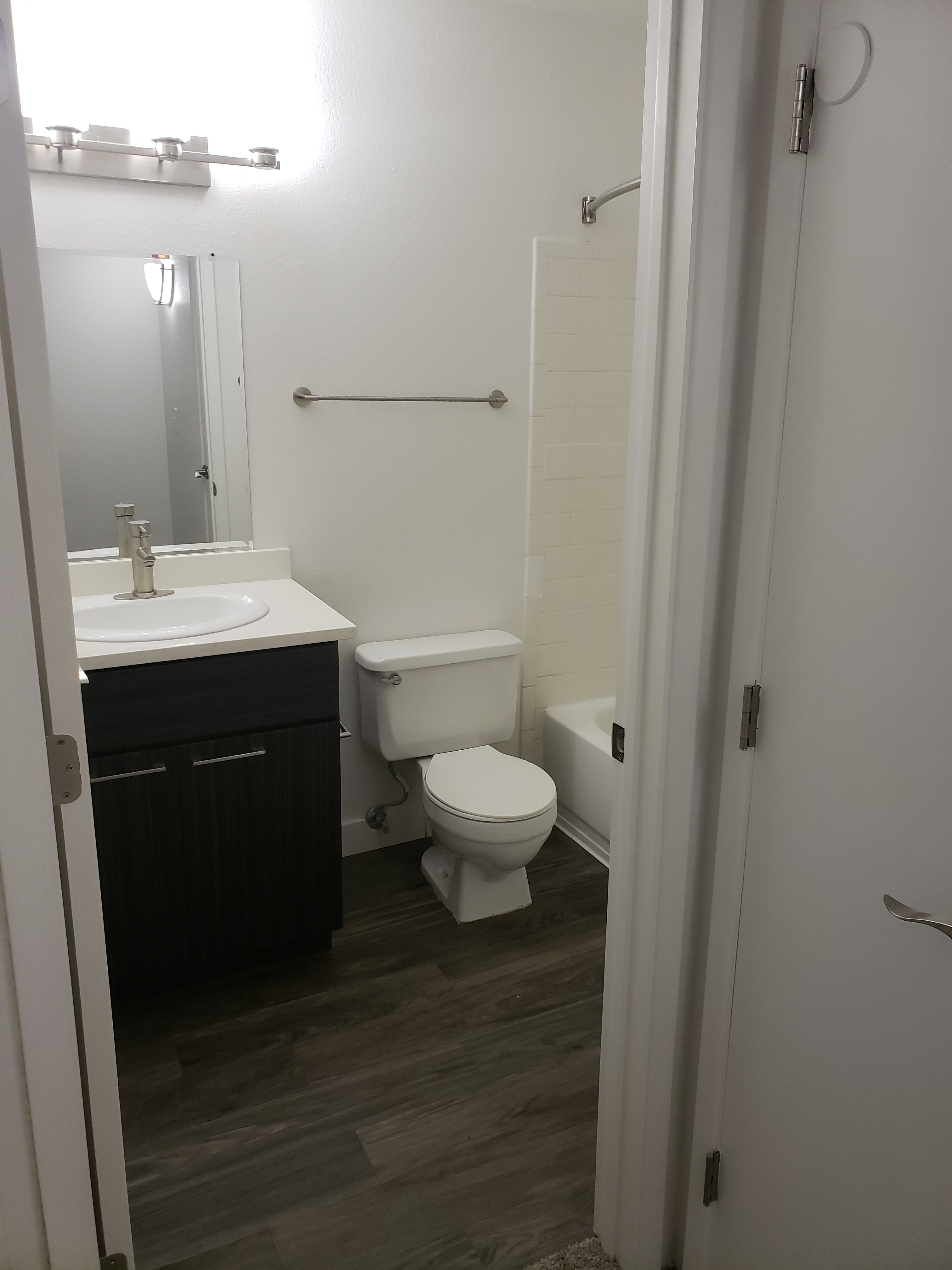 a white sink sitting under a mirror