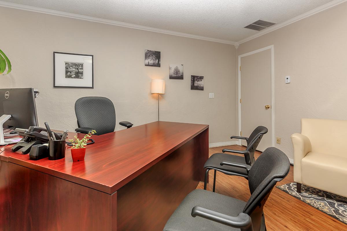 a living room with a desk and chair