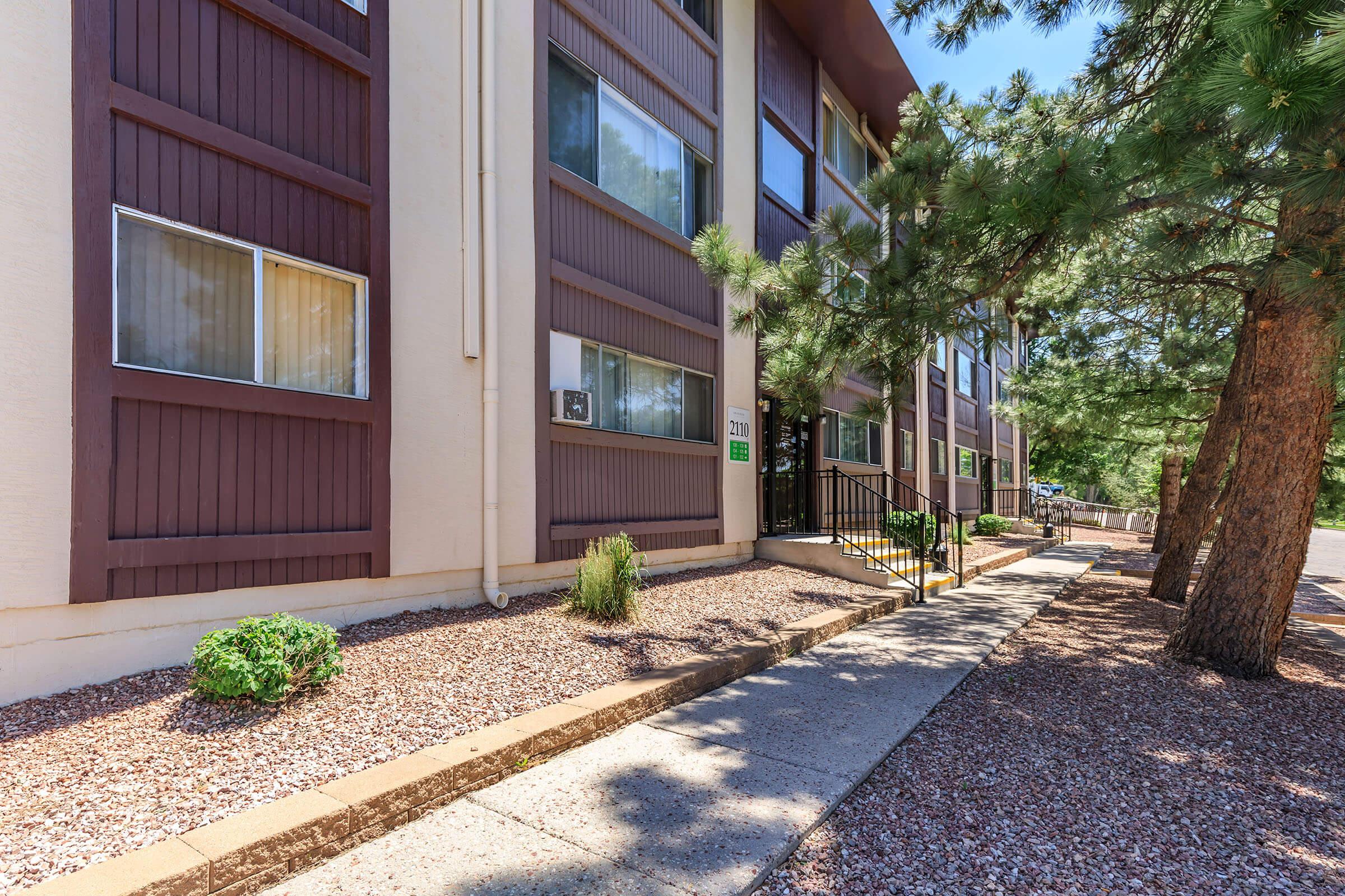 a path with trees on the side of a building