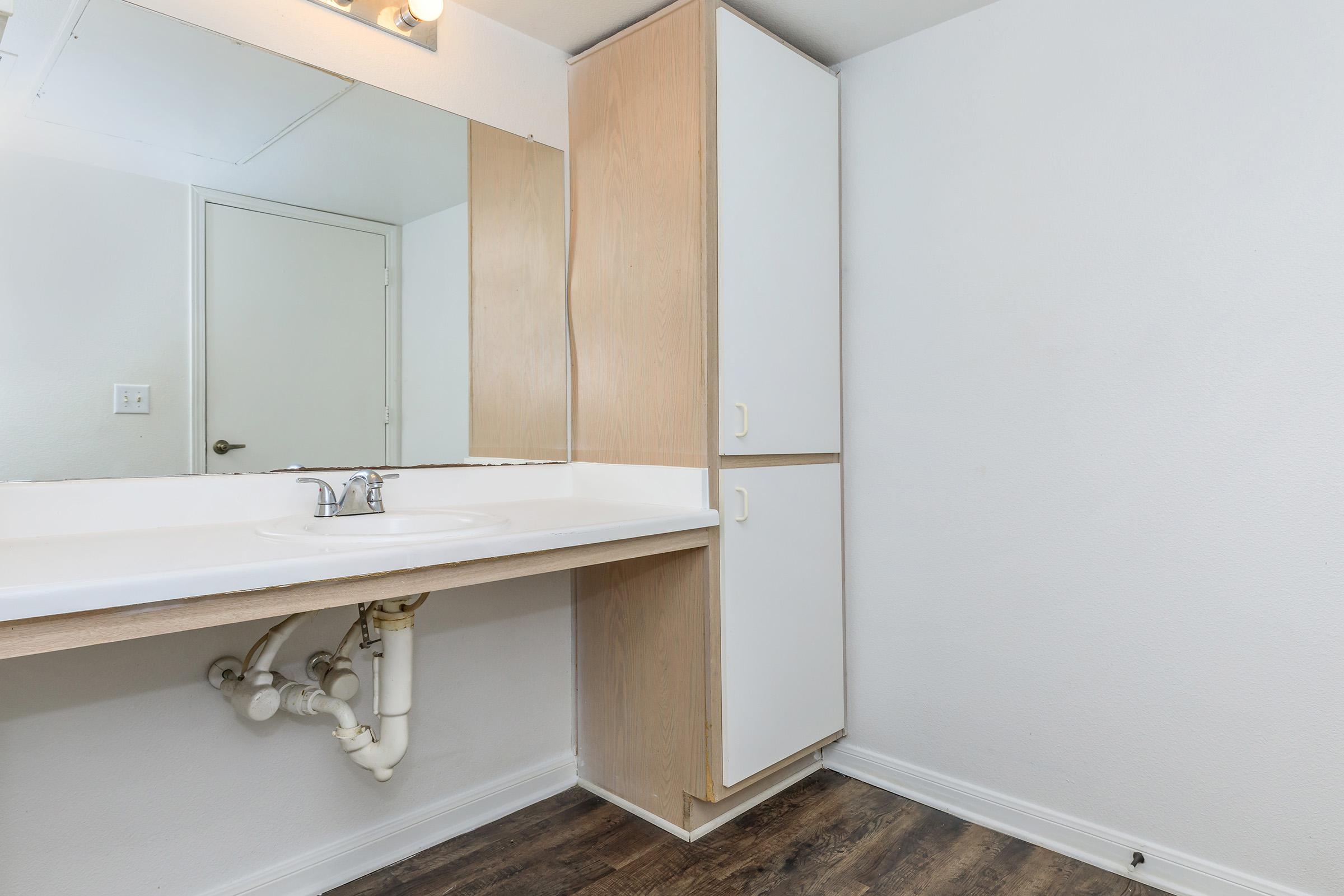 a kitchen with a sink and a mirror