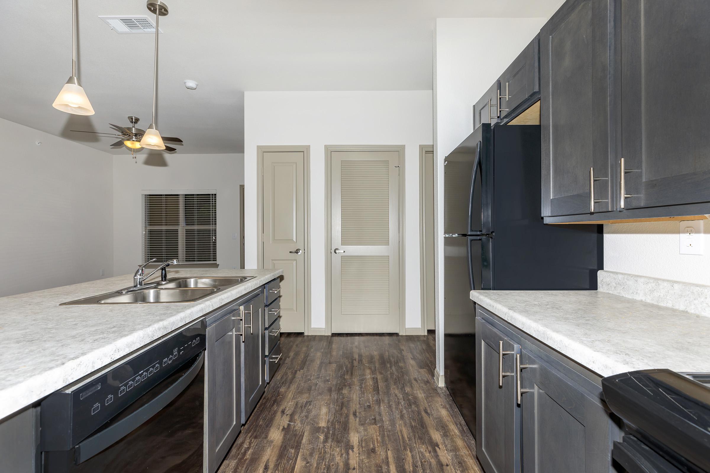 a modern kitchen with stainless steel appliances and wooden cabinets