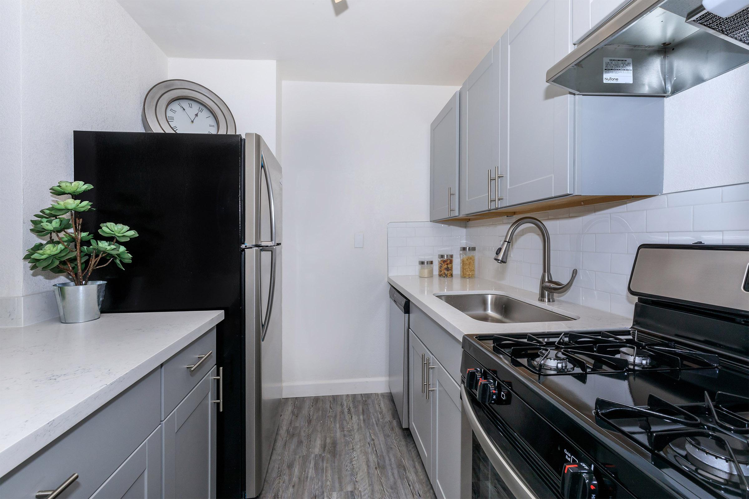 The Wexlers stainless steel kitchen with gray kitchen cabinets.