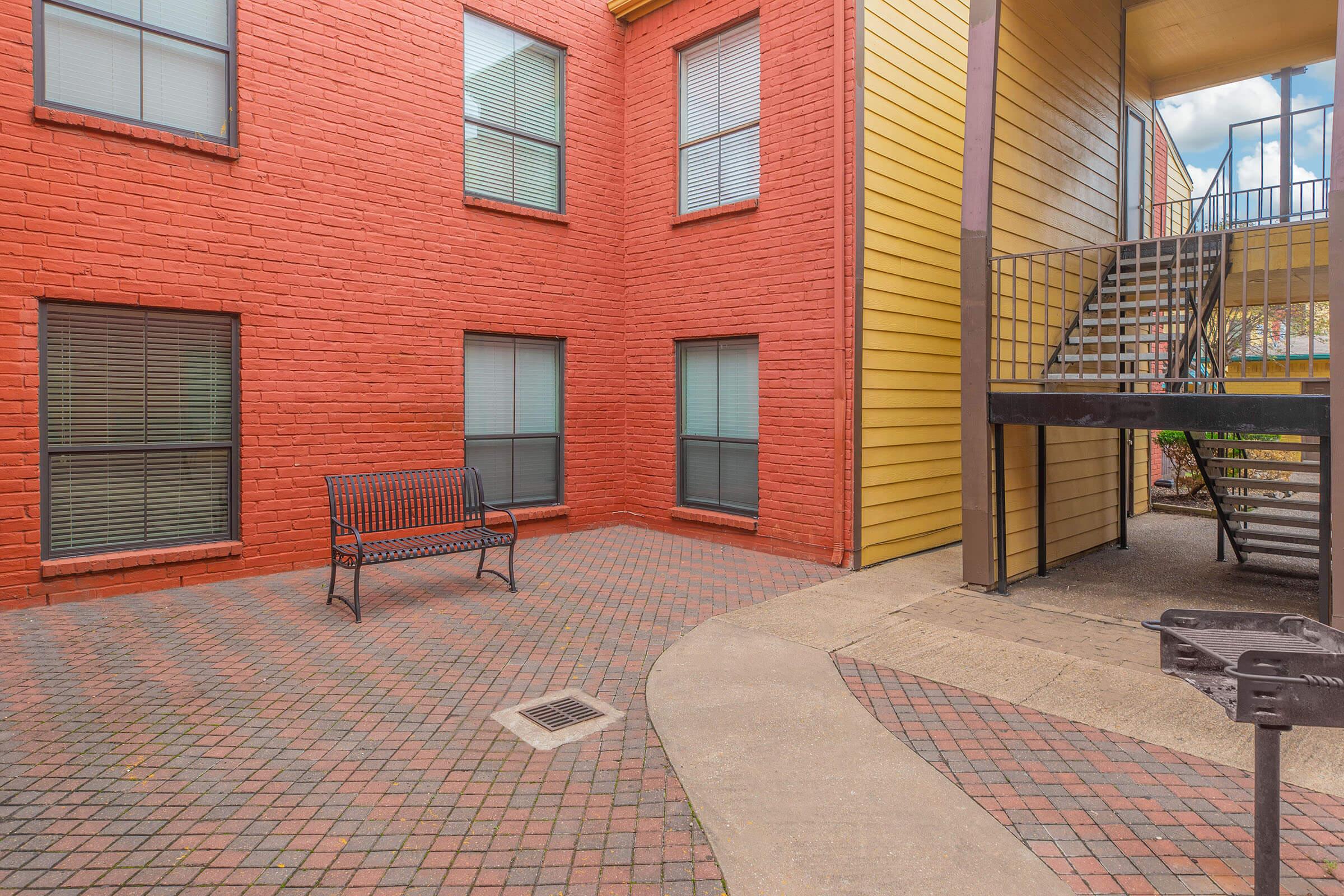 a bench in front of a brick building