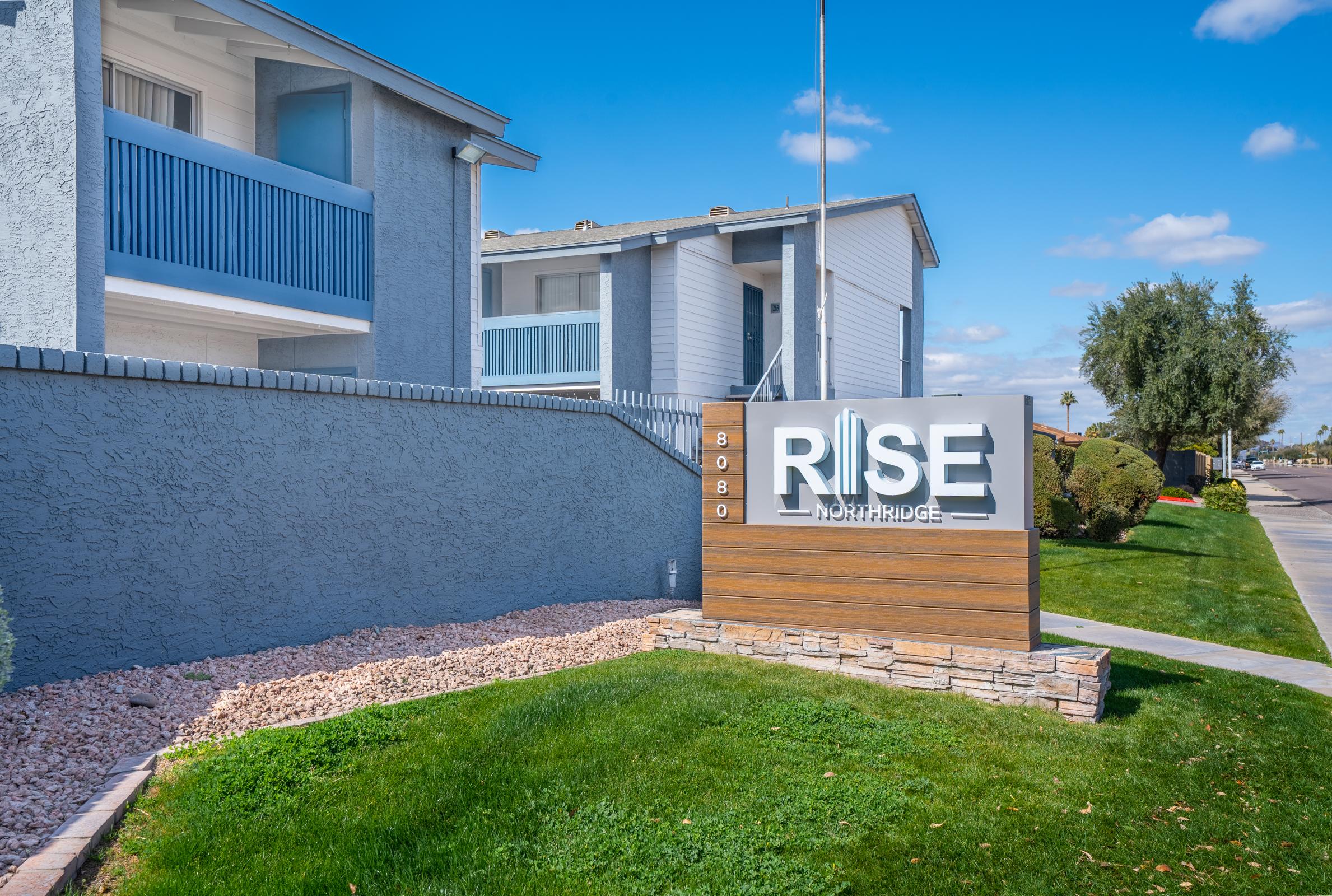 Front signage for Rise North Ridge with the apartments behind it.