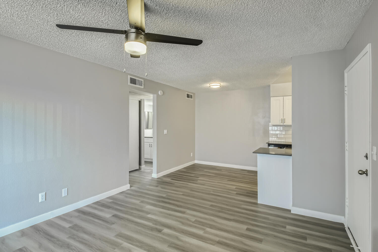 A living room, dining room, and a kitchen in an open-concept apartment at Rise North Ridge.