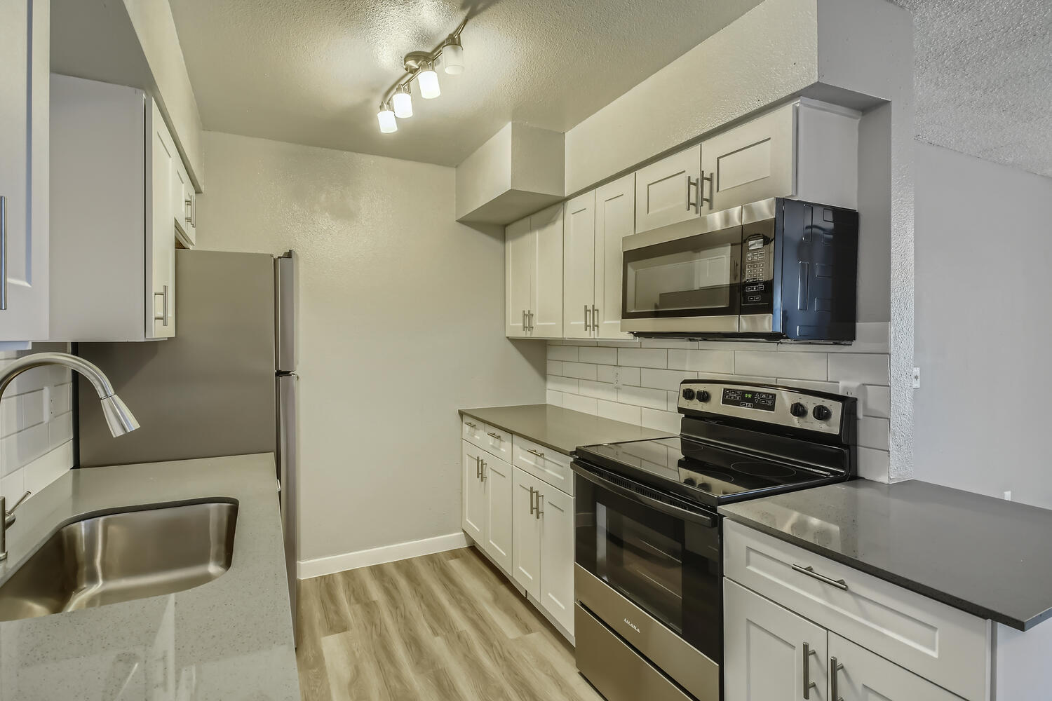 A remodeled kitchen with stainless steel appliances and a backsplash at Rise North Ridge.