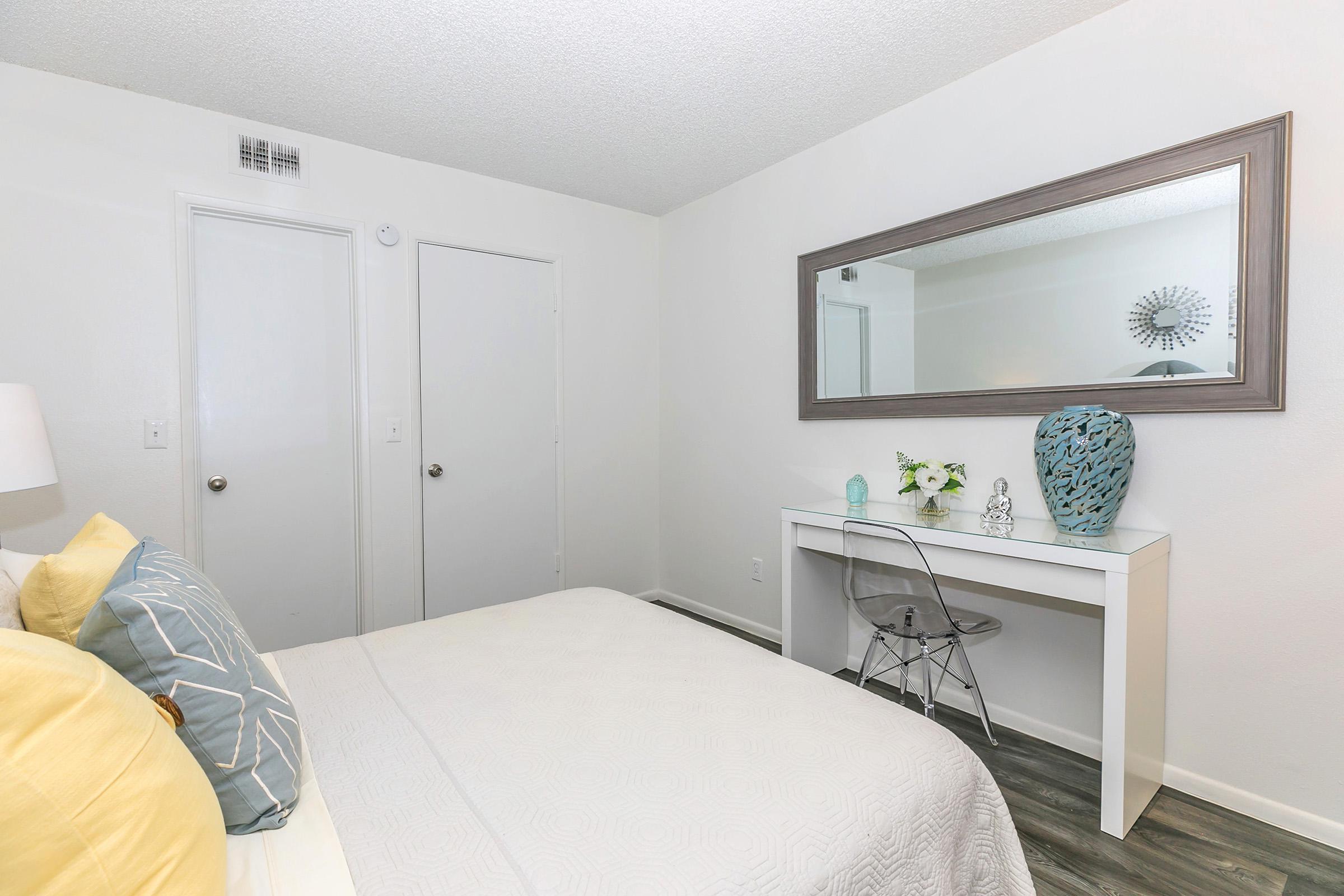 A bedroom with a queen bed and a desk at Rise North Ridge in Glendale, AZ.