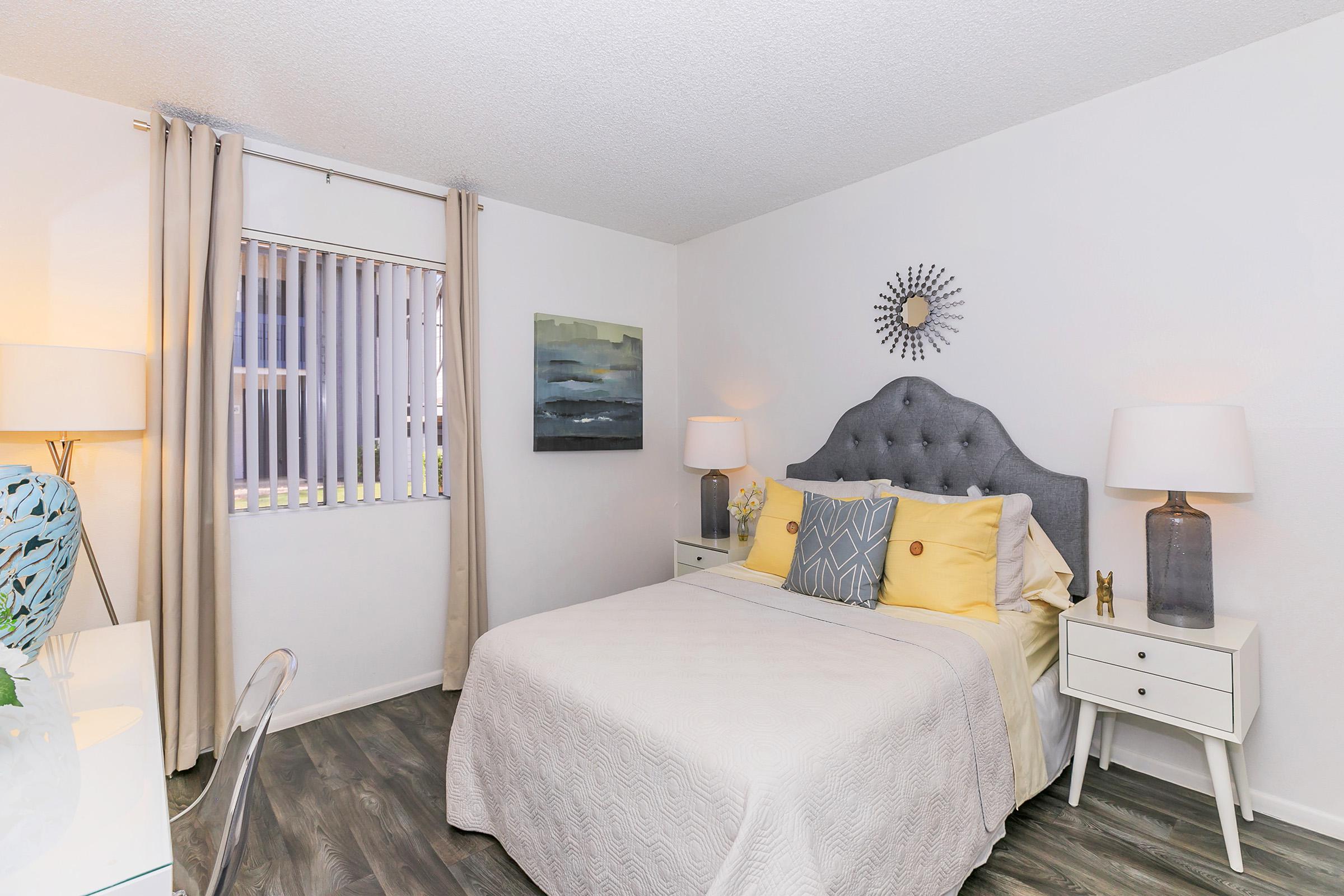 A queen bed in a bedroom with a window at Rise North Ridge.
