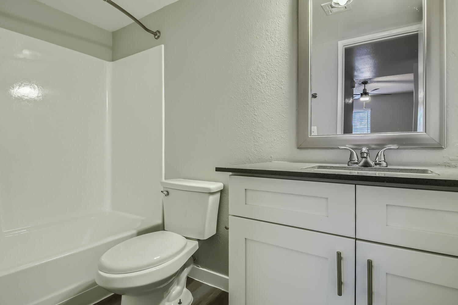 A bathroom with a vanity, mirror, and a shower at Rise North Ridge.