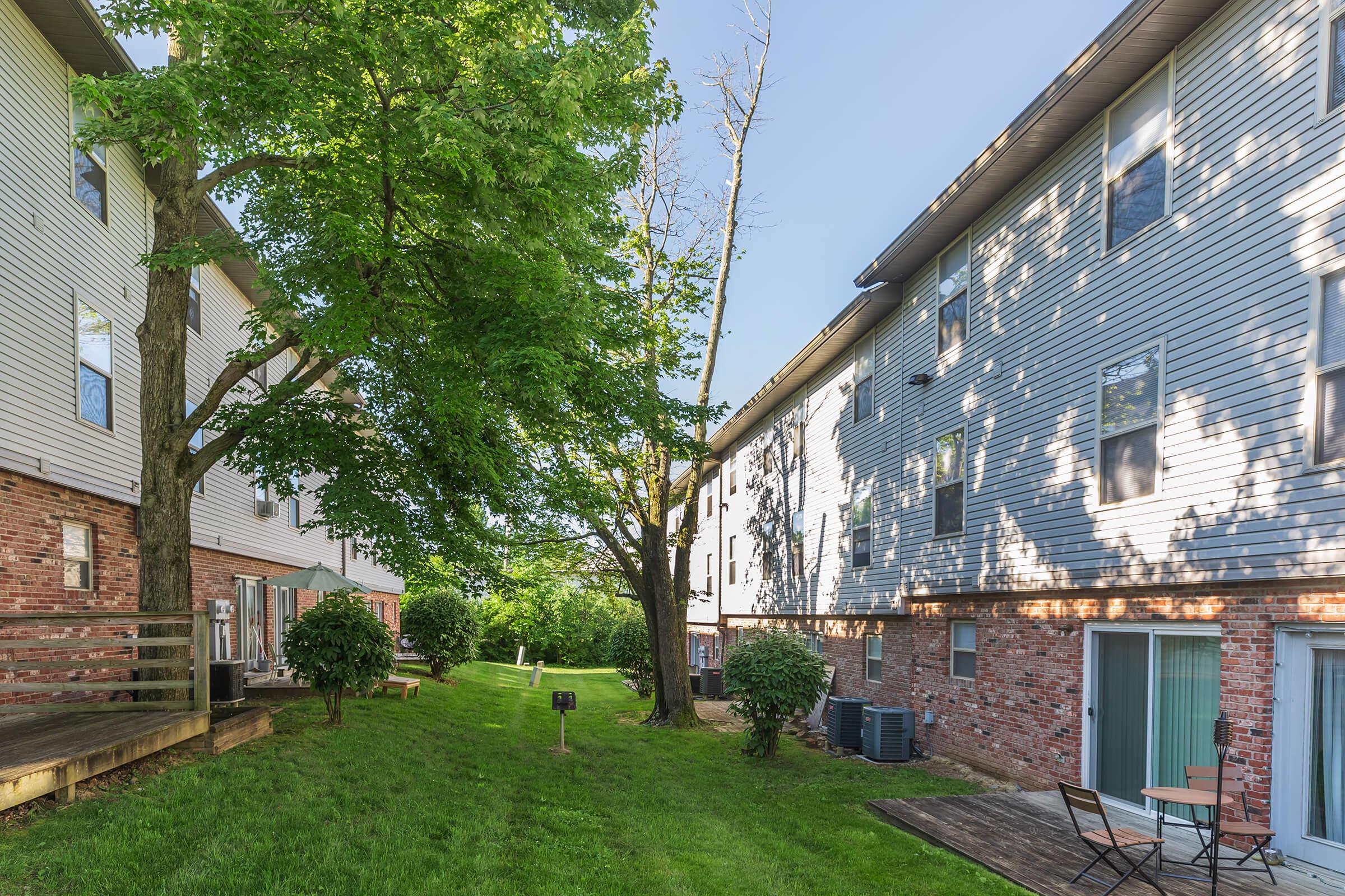 a large brick building with grass in front of a house