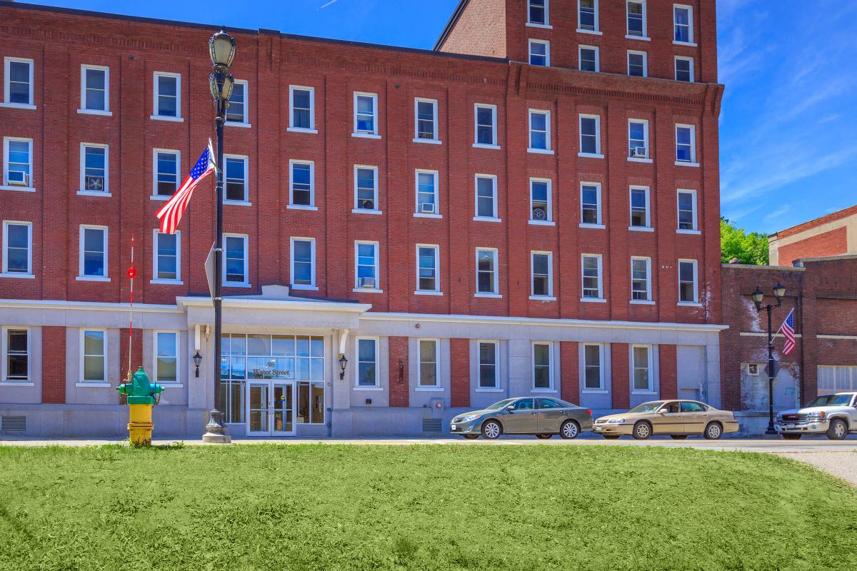 a large brick building with green grass