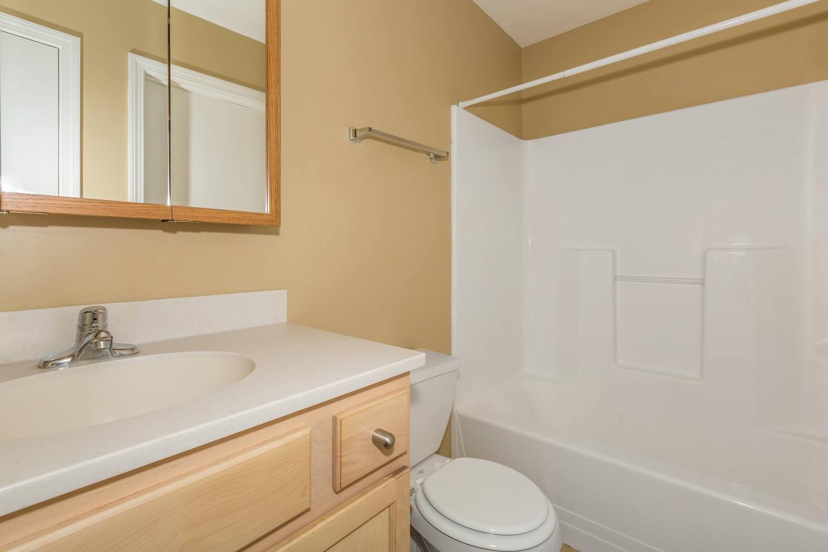 a white sink sitting under a mirror