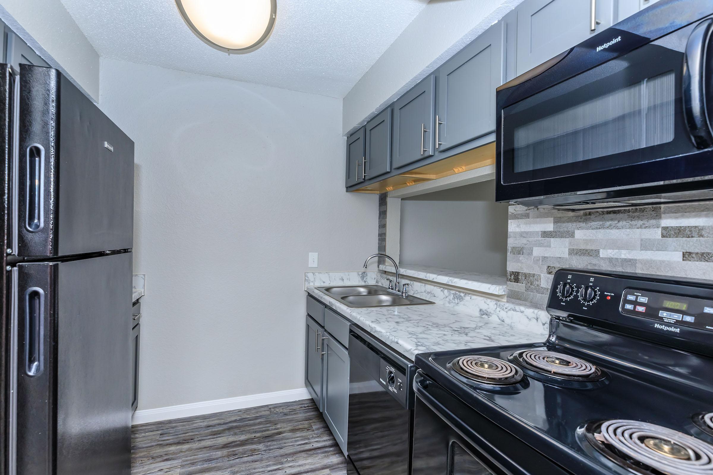 a stove top oven sitting inside of a kitchen with stainless steel appliances