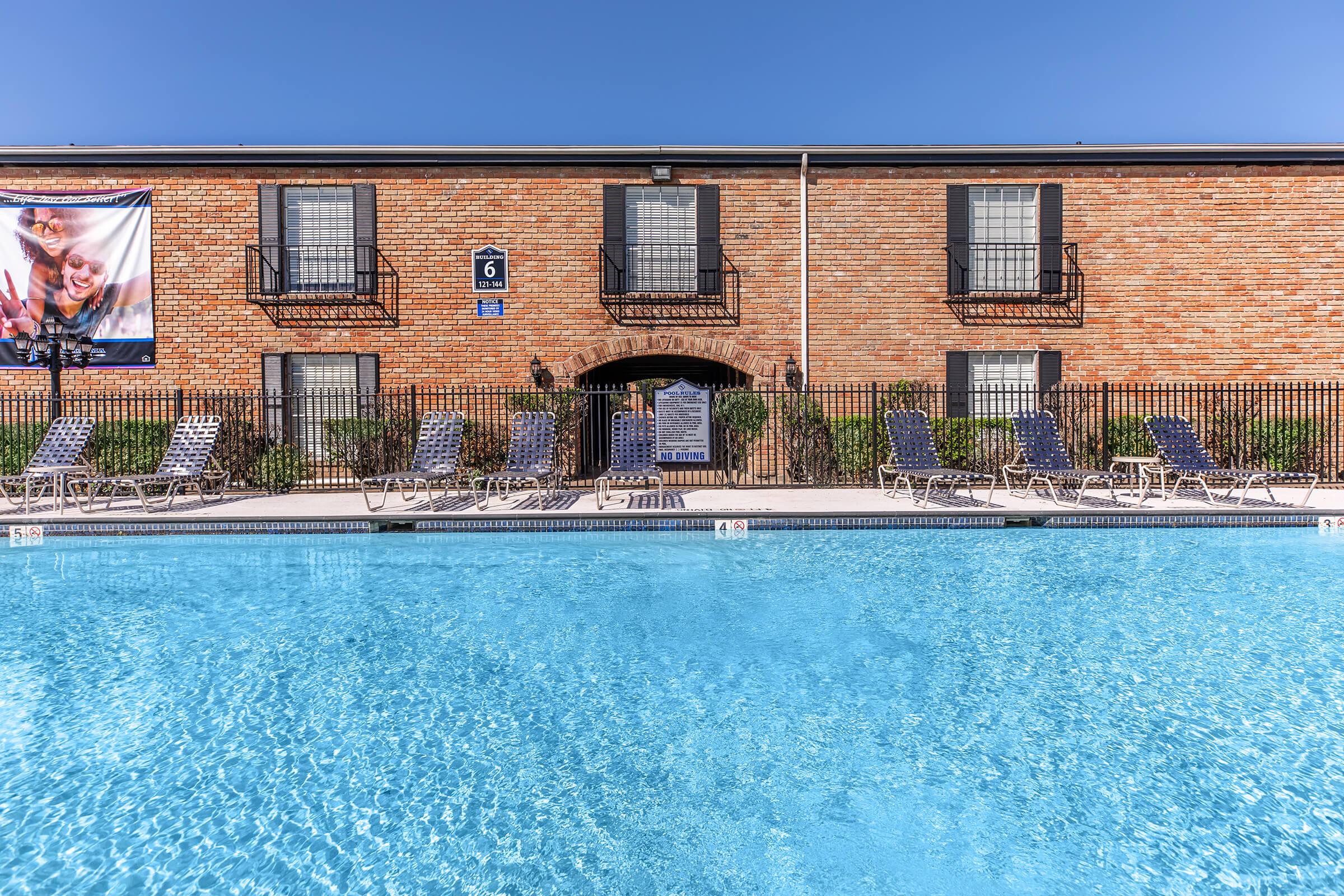 a large brick building with a pool of water