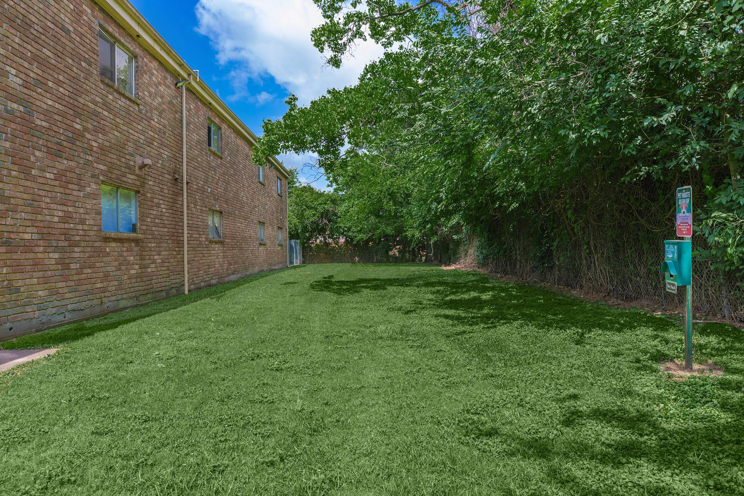 a large brick building with green grass