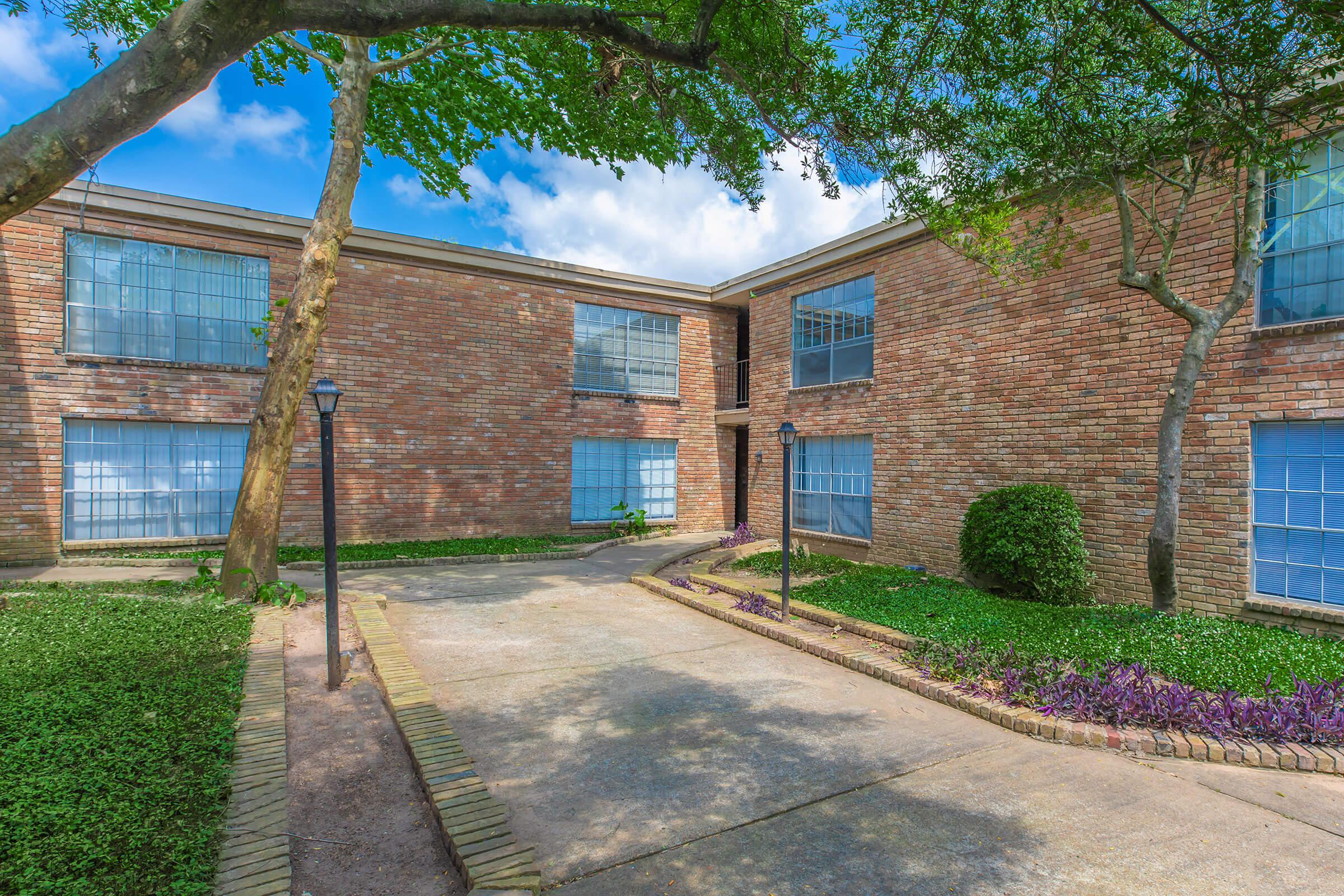 a tree in front of a brick building