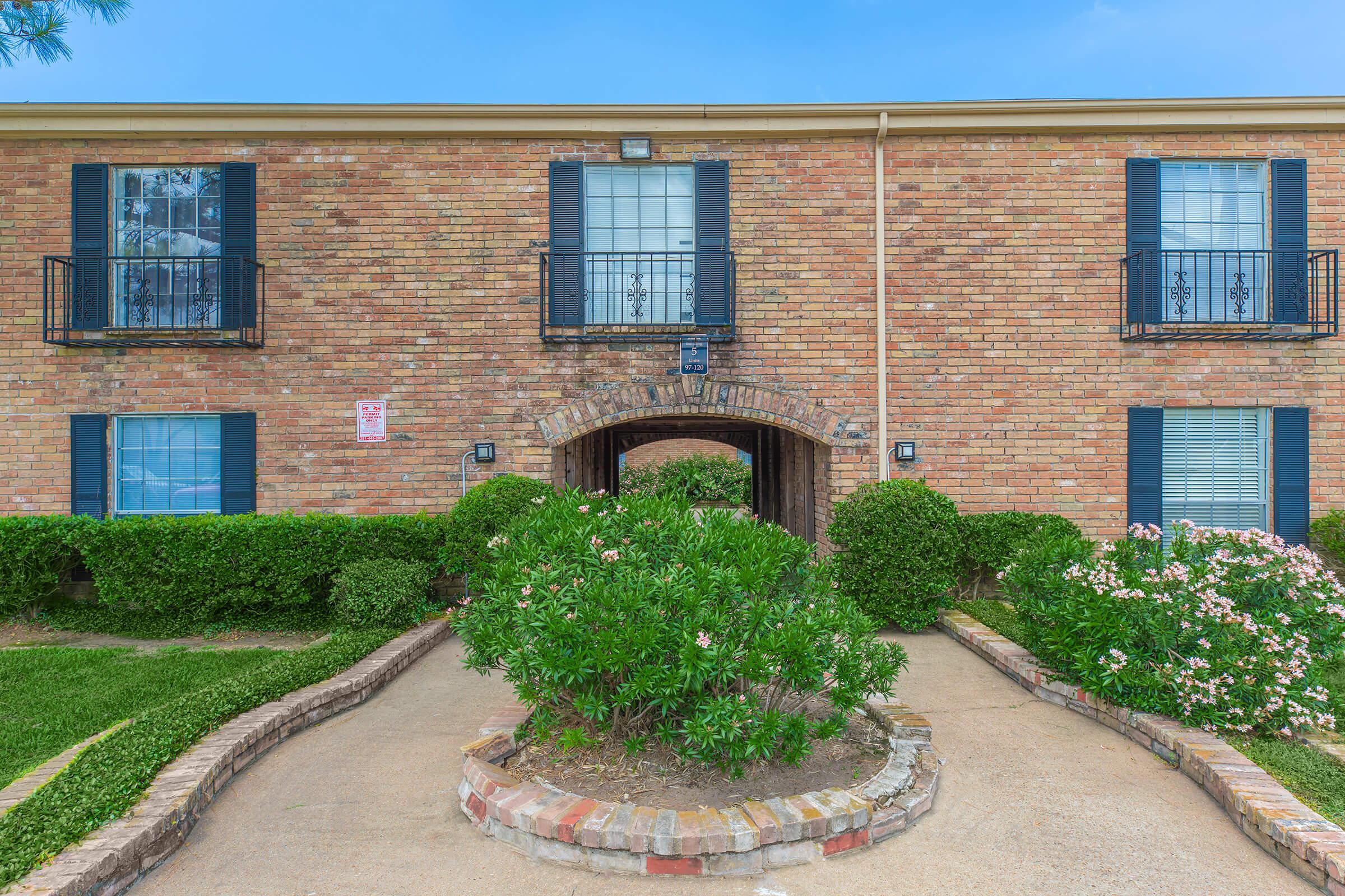 a garden in front of a brick building