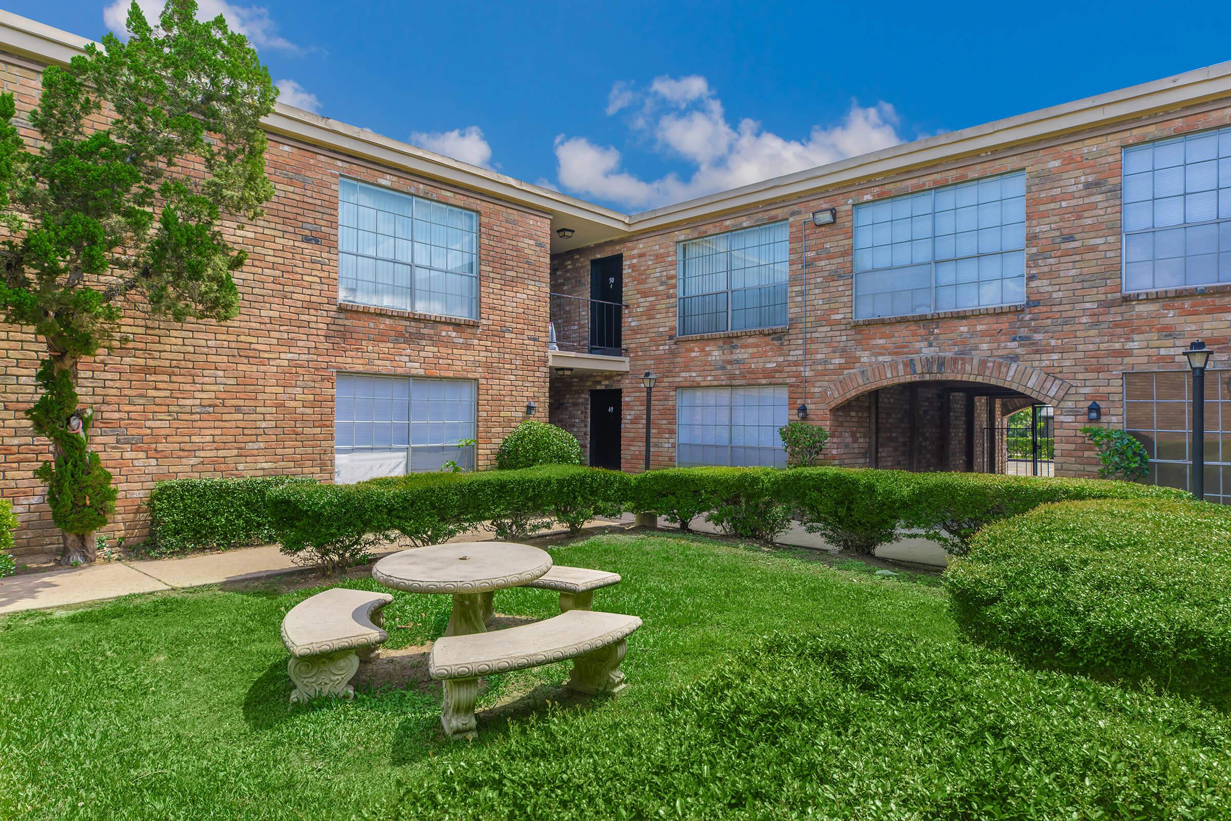 a large lawn in front of a brick building