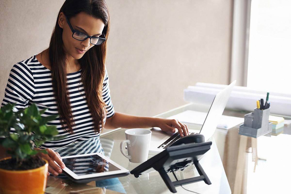 a woman sitting at a table using a laptop