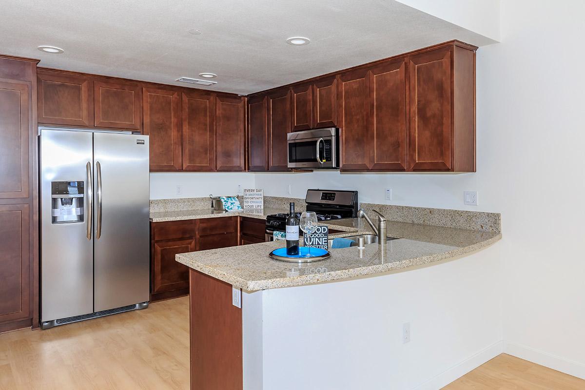 4-Bedroom Townhomes in Chula Vista, CA - Contessa at Otay Ranch - A Kitchen with Warm Wood Cabinetry and Stainless-Steel Appliances.