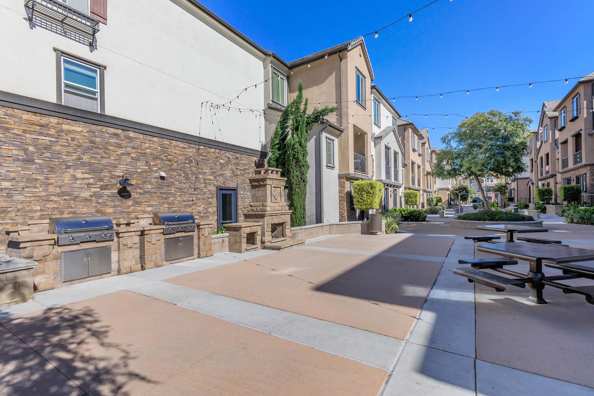 3-Bedroom Townhomes in Chula Vista, CA - Contessa at Otay Ranch - A Grilling Station with Two Stainless-Steel Barbecue Grills and Round Picnic-Style Seating.