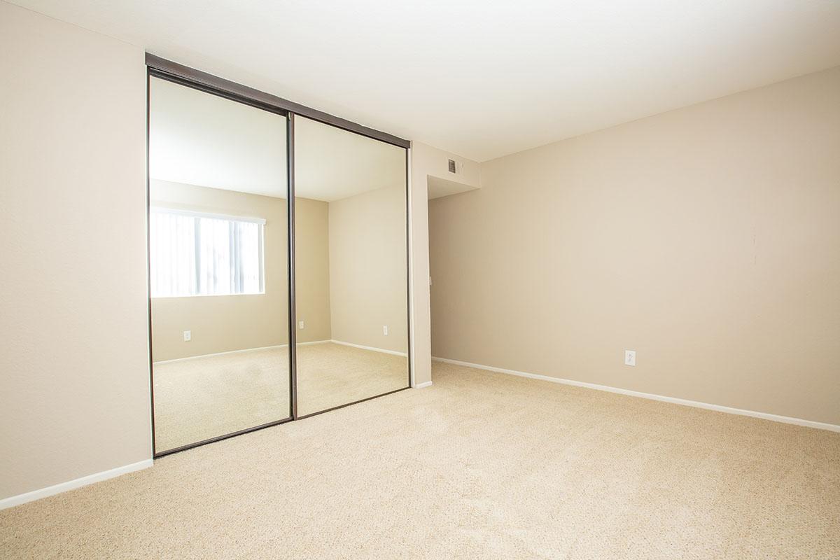 Unfurnished bedroom with glass mirror sliding closet doors