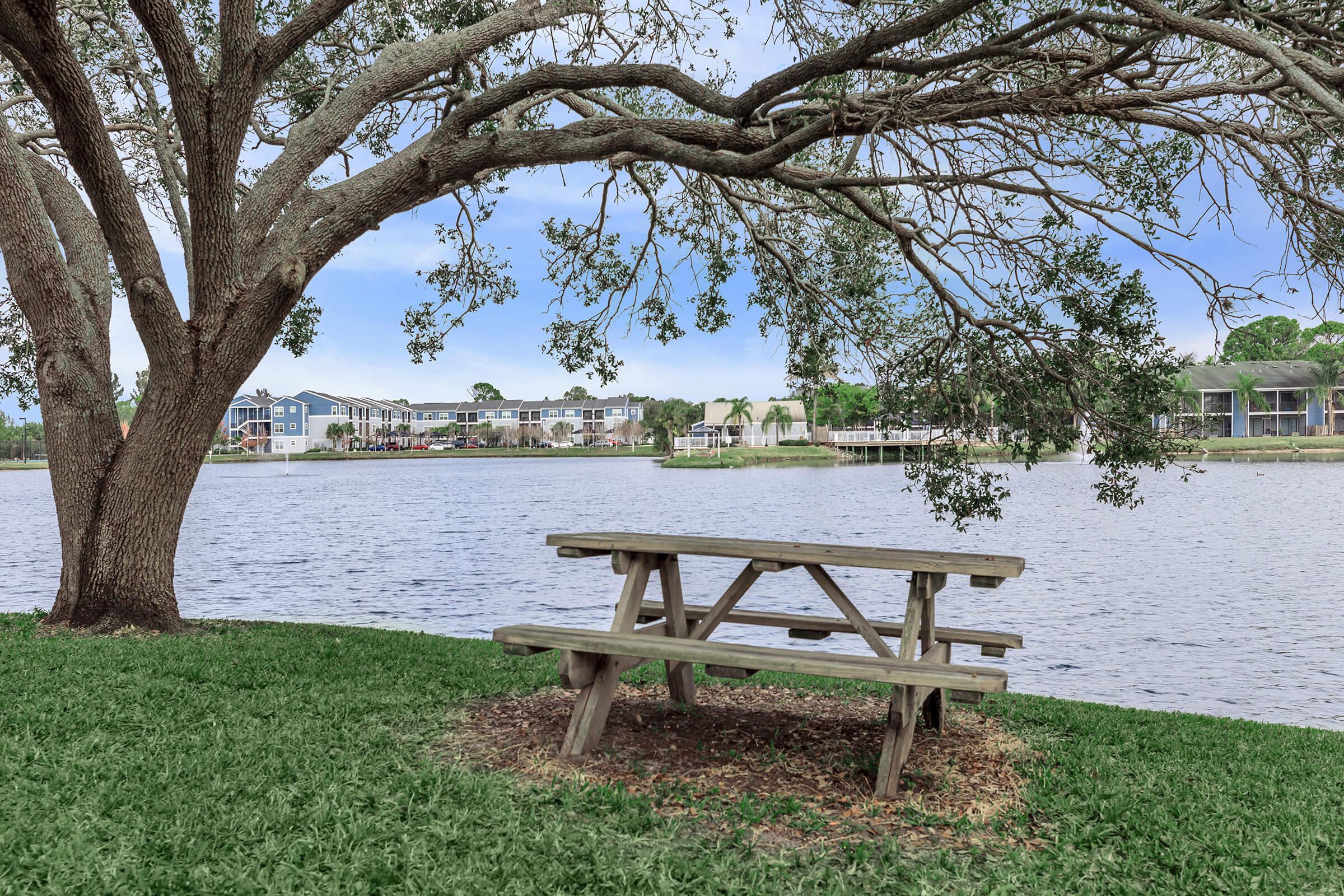 a wooden park bench sitting in front of a body of water