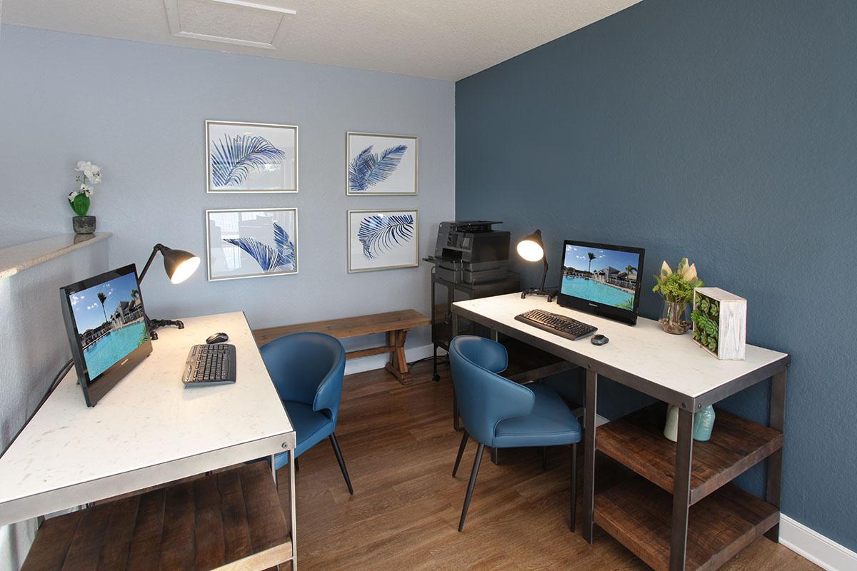 a desk with a computer and a chair in a room