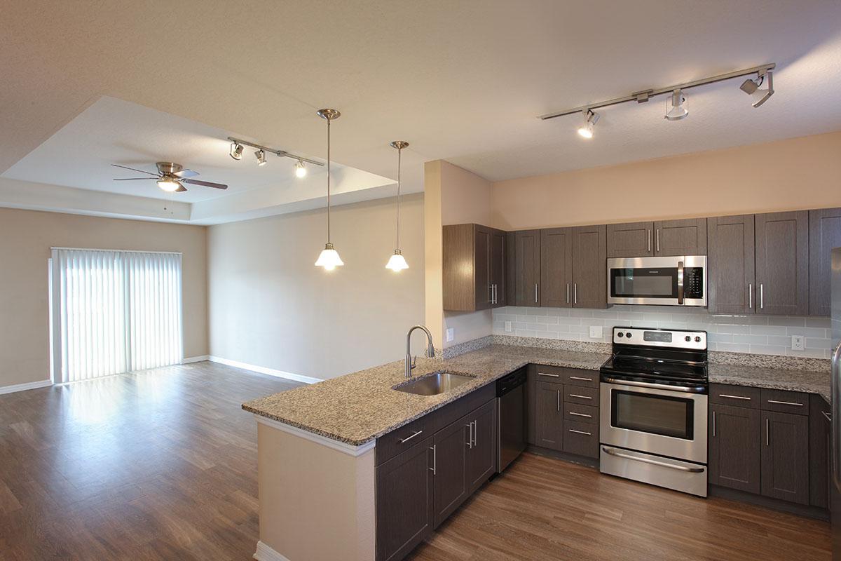 a modern kitchen with stainless steel appliances and wooden cabinets