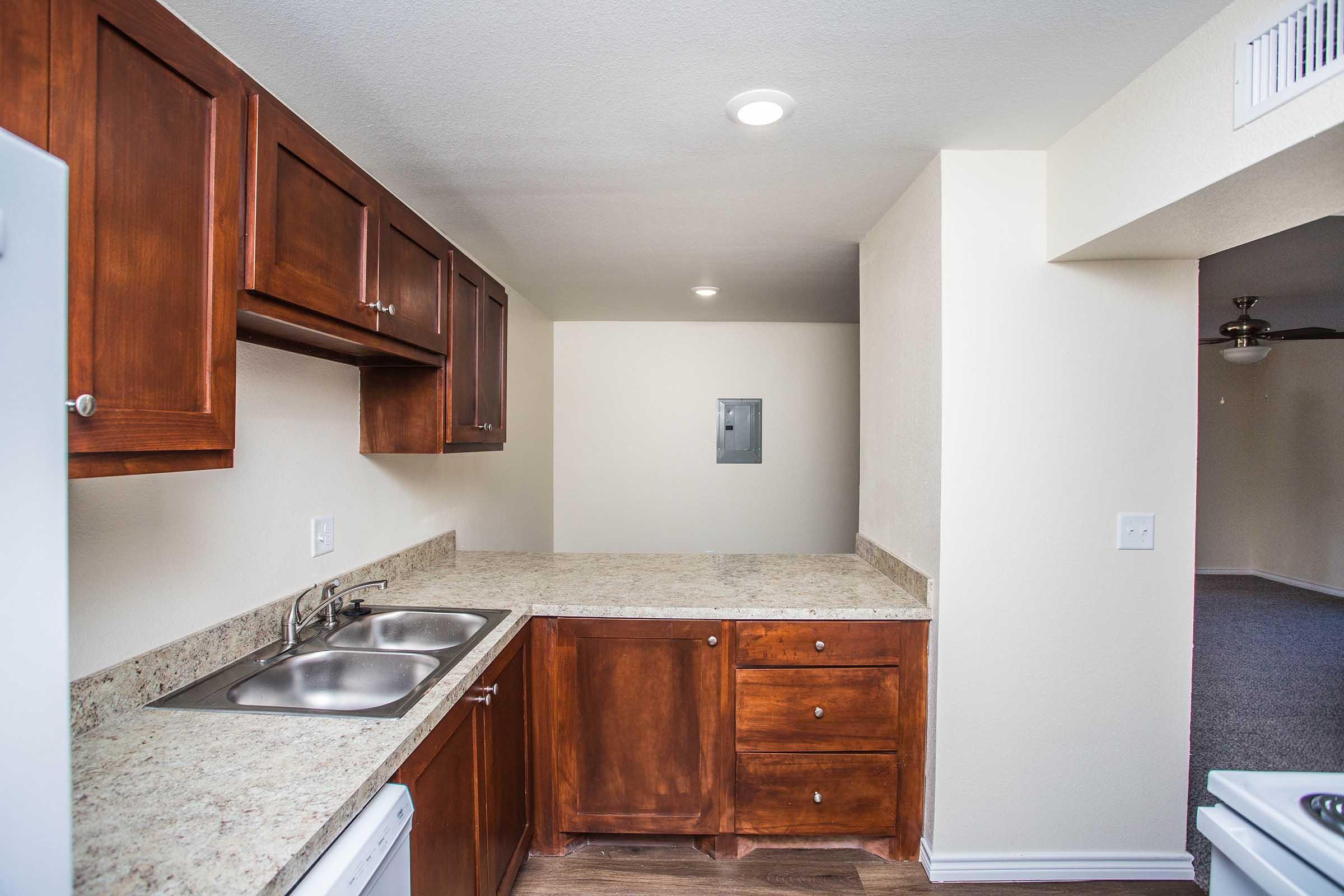 a large kitchen with stainless steel appliances and wooden cabinets