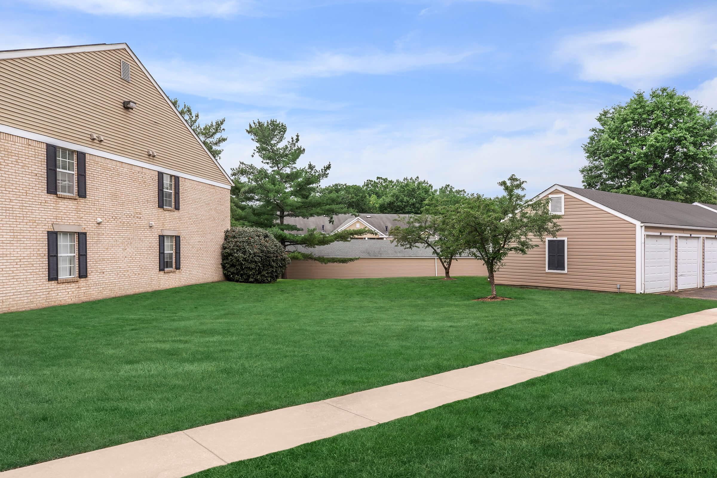 a large brick building with grass in front of a house