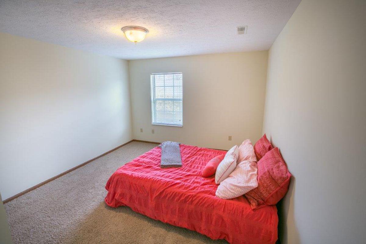 a bedroom with a red blanket