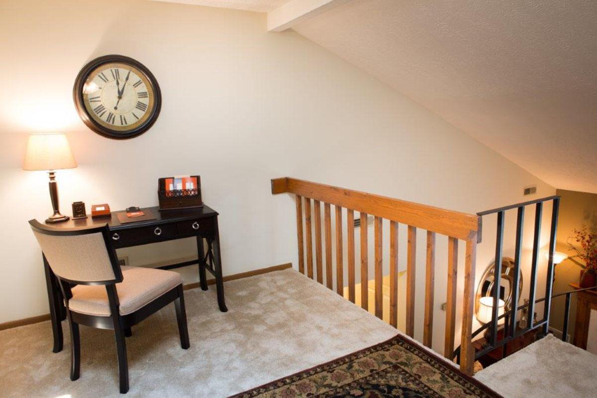 a living room with a clock at the top of a wooden table