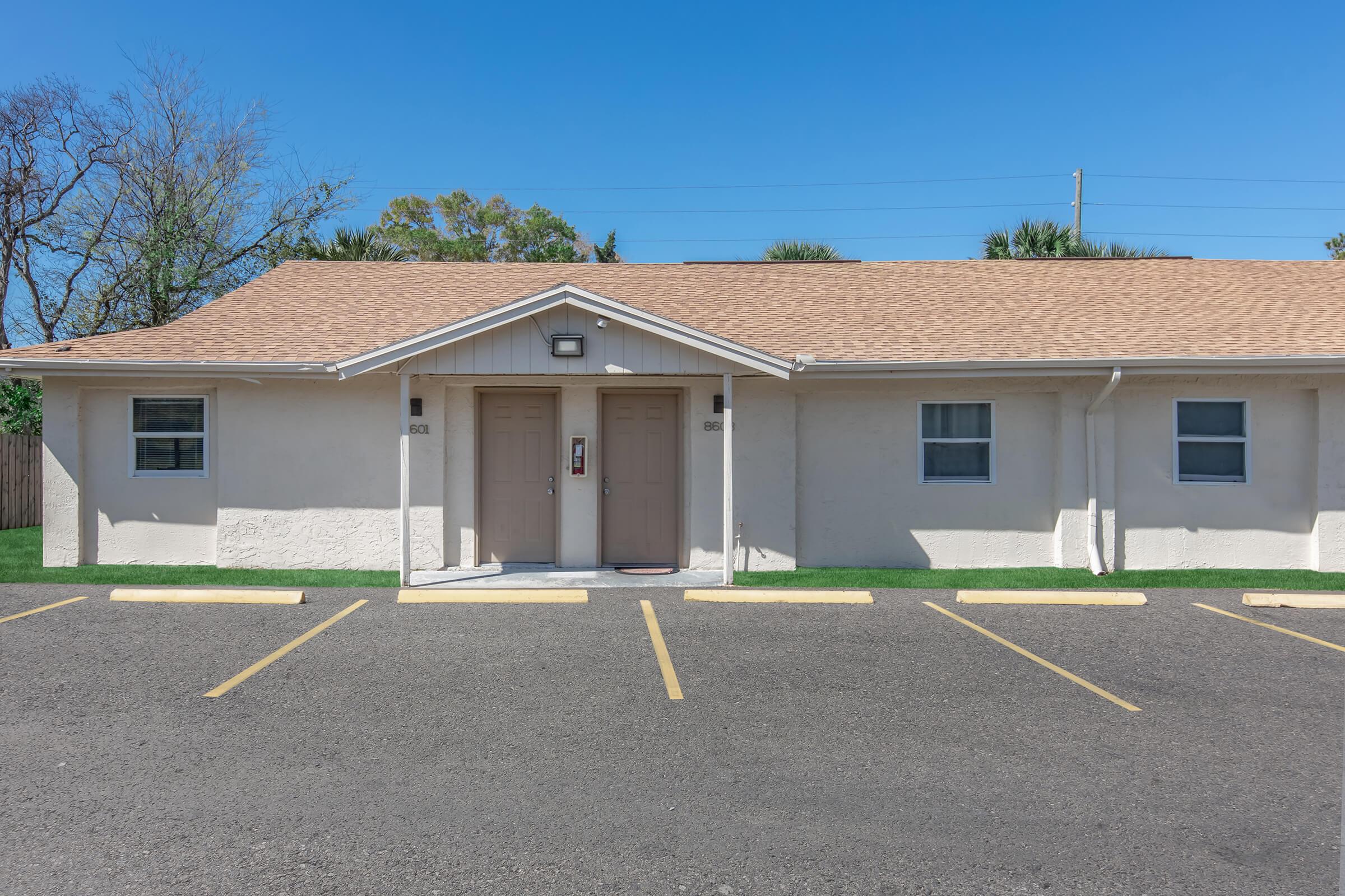 an empty parking lot in front of a house