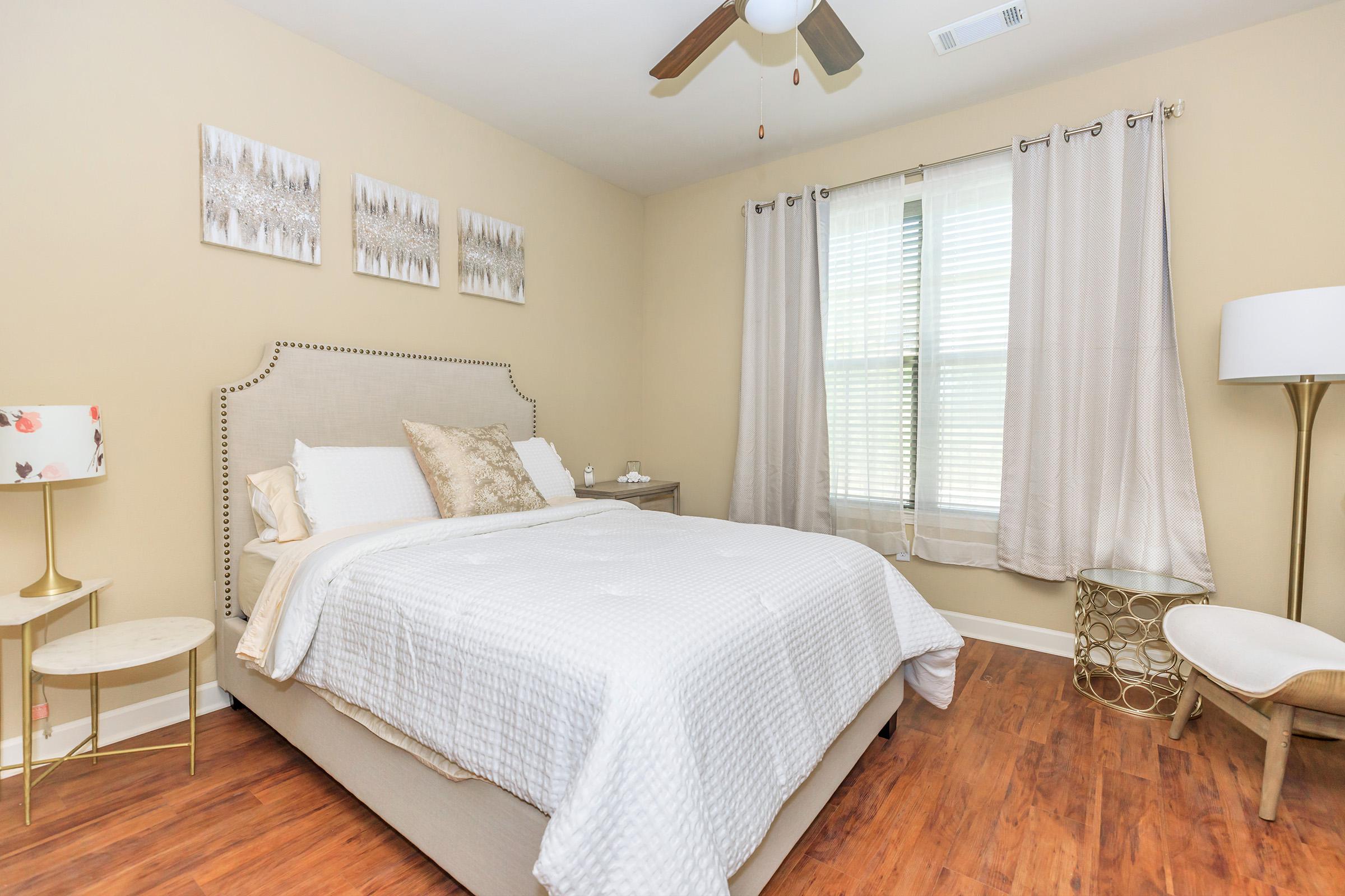 a bedroom with a bed and a chair in a room