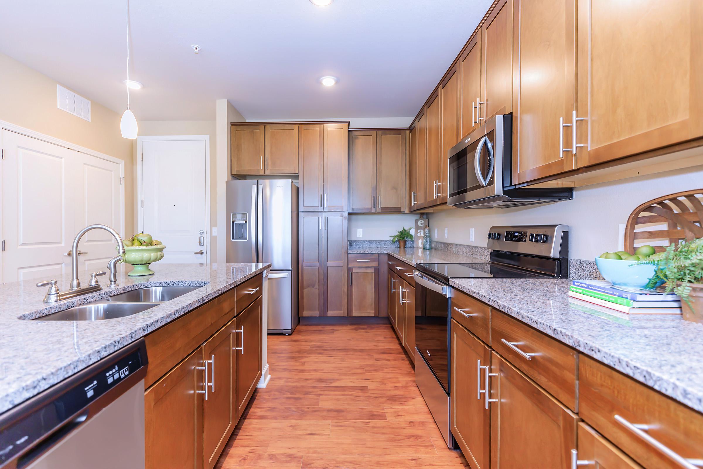 a modern kitchen with stainless steel appliances and wooden cabinets