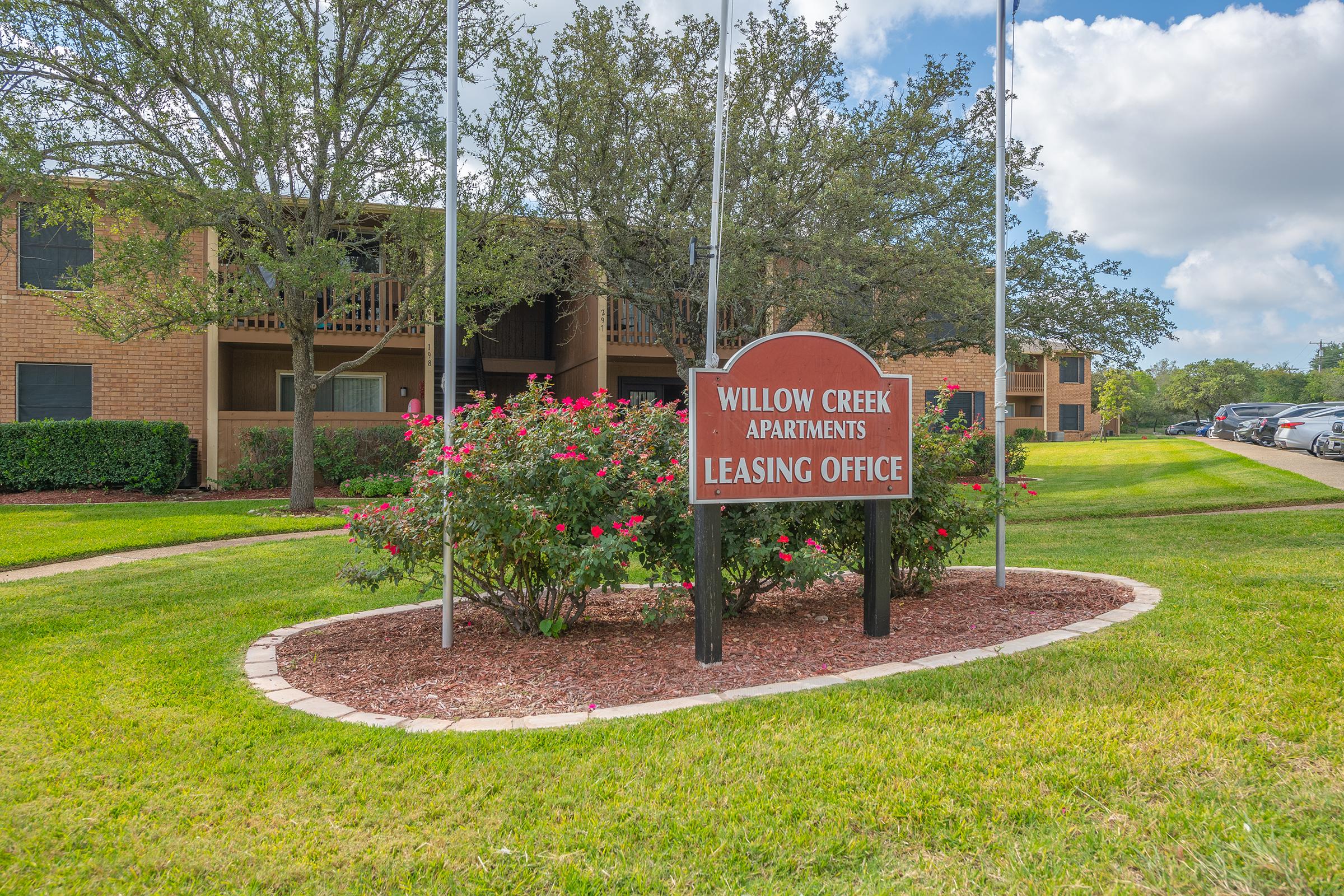 a sign over a grassy area