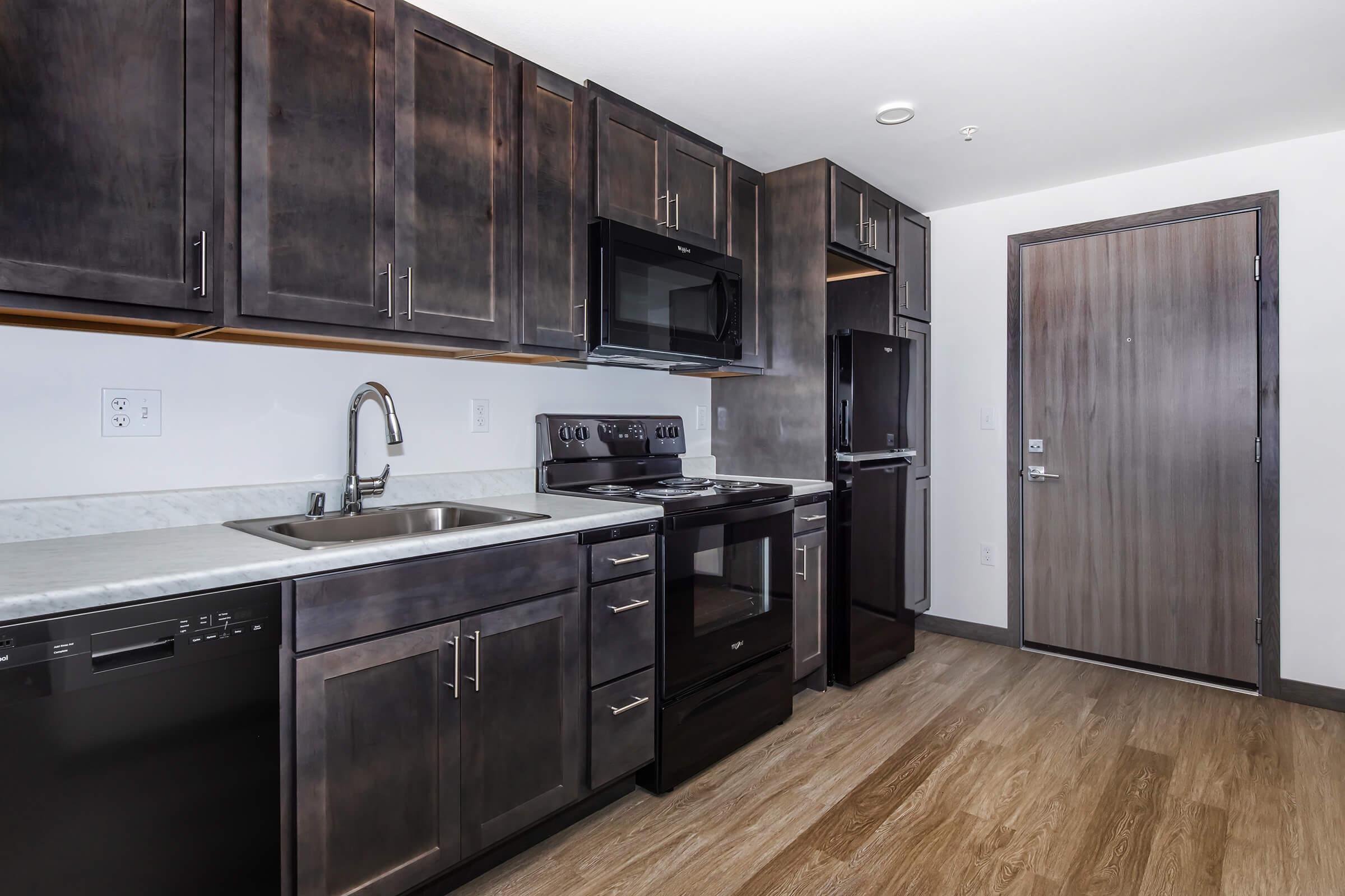 a large kitchen with stainless steel appliances and wooden cabinets