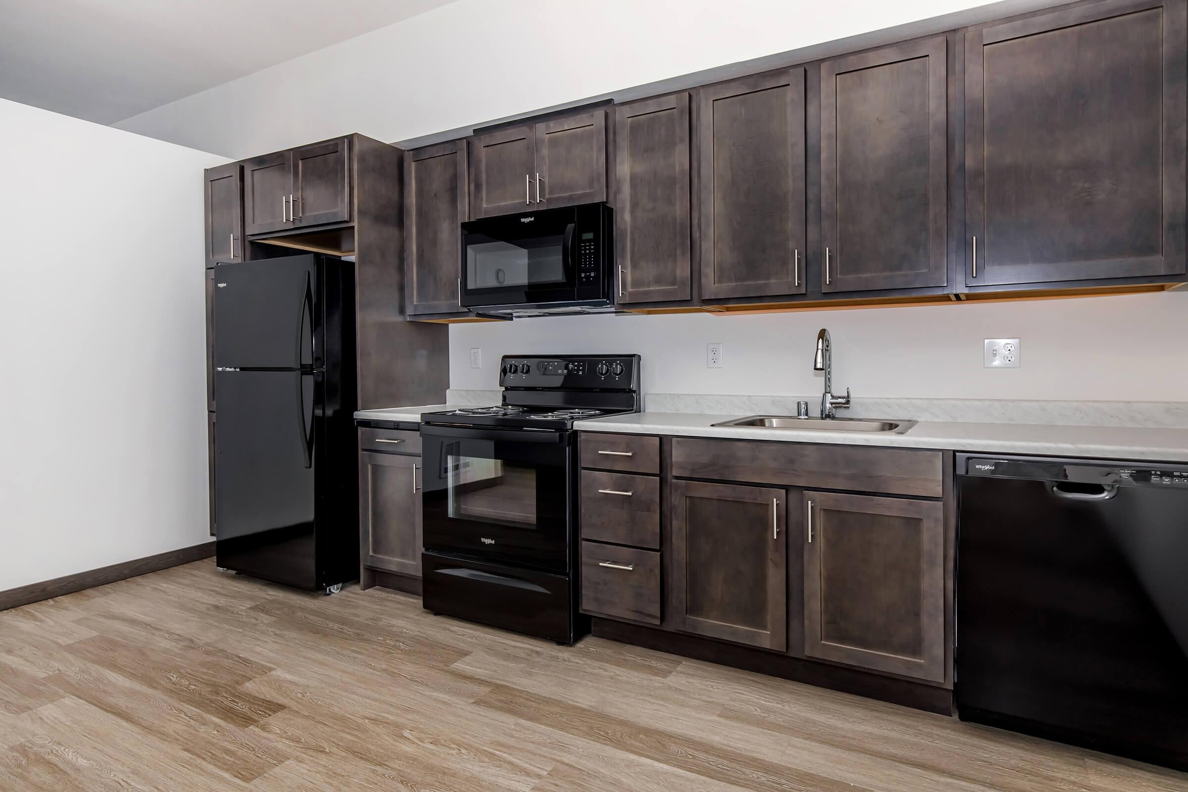 a large kitchen with stainless steel appliances and wooden cabinets