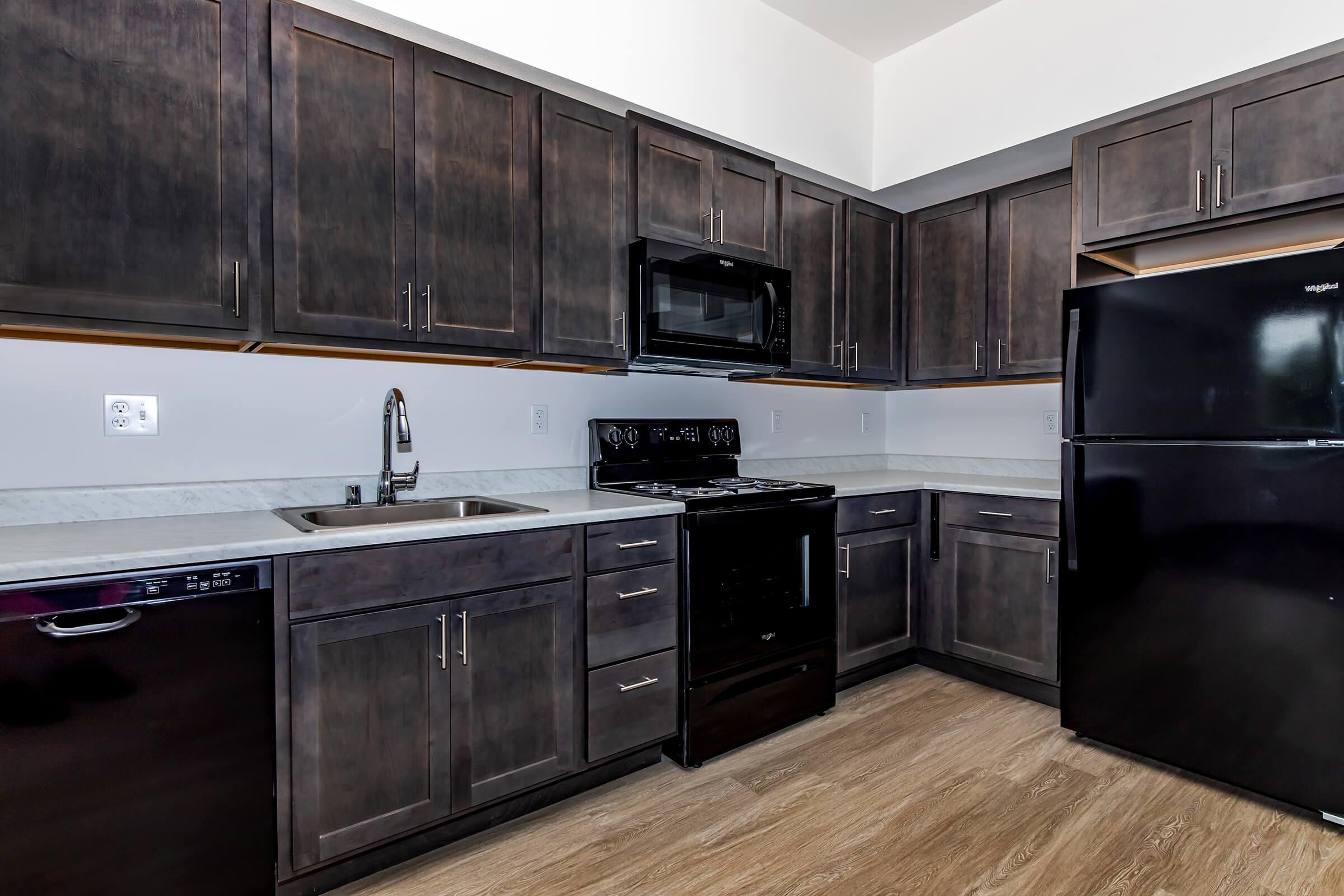 a large kitchen with stainless steel appliances and wooden cabinets