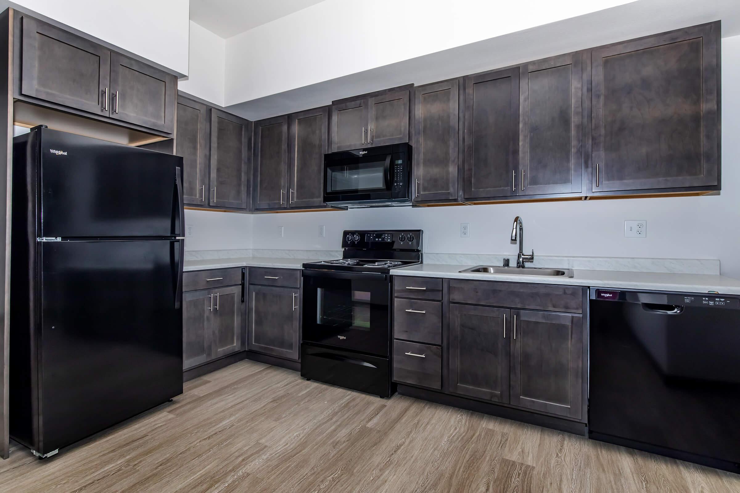 a large kitchen with stainless steel appliances and wooden cabinets