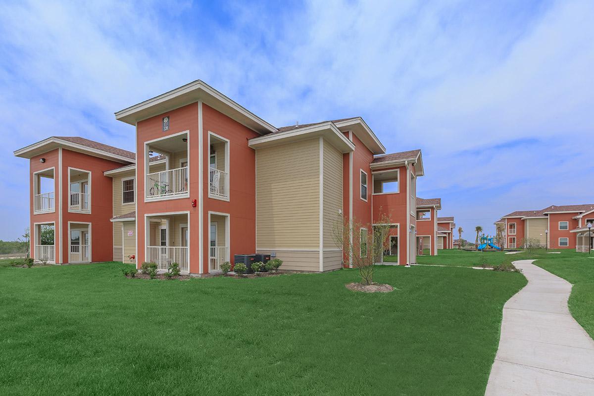 a house with a lawn in front of a brick building