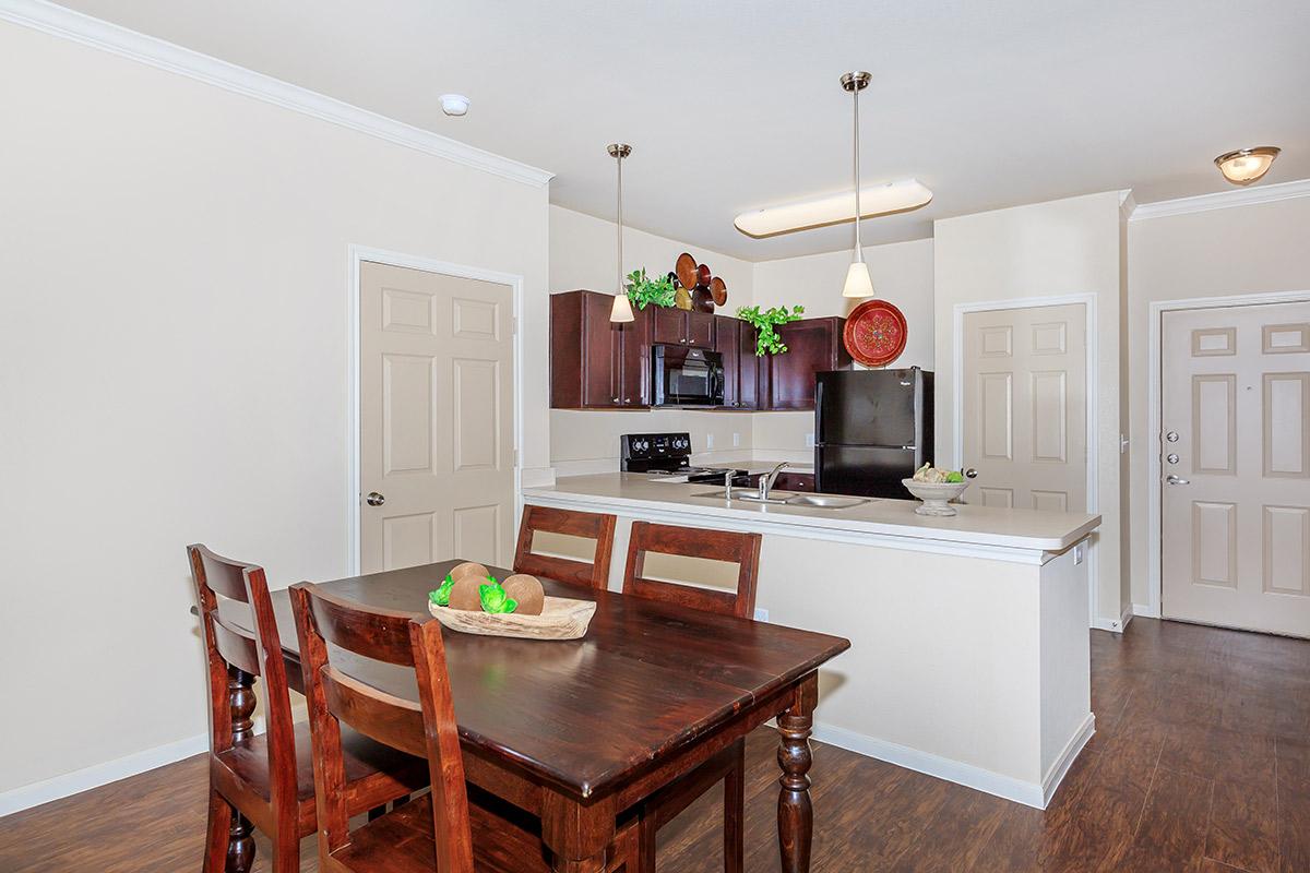 a kitchen with wooden cabinets and a dining room table