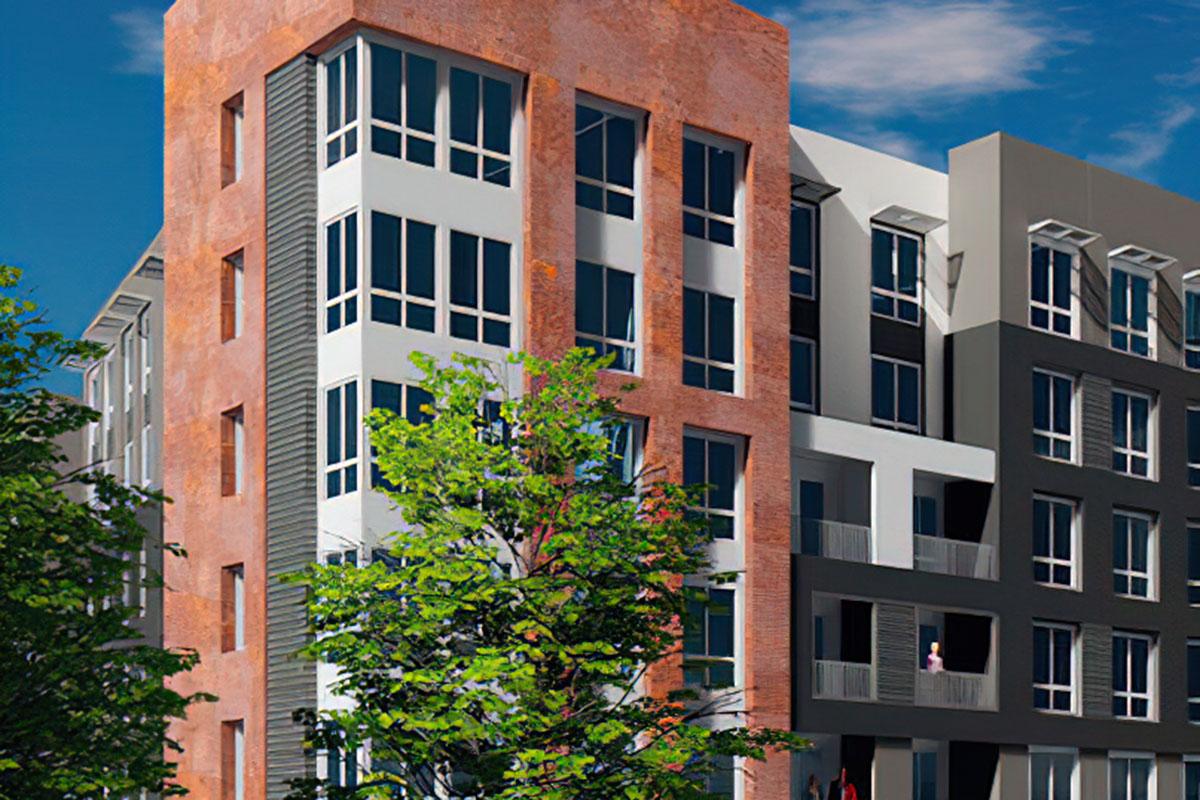 A modern multi-story building featuring a mix of brick and gray façade, large windows, and a contemporary design.